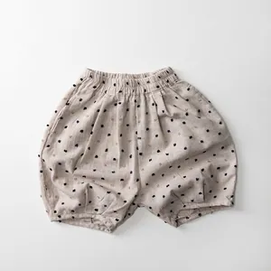 Detail of kids linen bloomers showing elastic waist and embroidered polka dot pattern