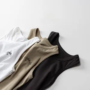 Dettaglio di tre canotte in cotone nei colori bianco, kaki e nero con stampa Summer
