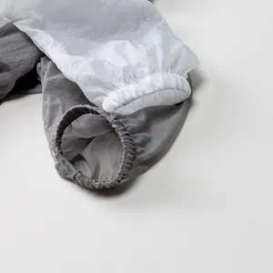 Détail de manches de protection solaire légères avec poignets élastiques en blanc et gris