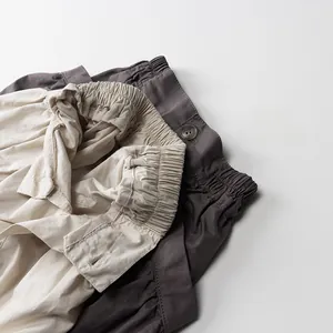 Détail de la taille élastique et bouton en résine sur short cargo en coton pour enfant