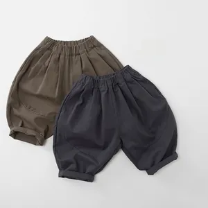 Close-up of cotton children wide-leg pants in charcoal grey and olive brown with elastic waist