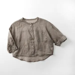 Détail du cardigan en ramie pour enfant montrant le tissu naturel et les boutons en bois