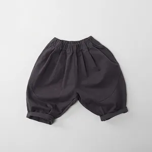 Flat lay of dark grey cotton kids wide-leg trousers with an elastic waist and cuffed hem