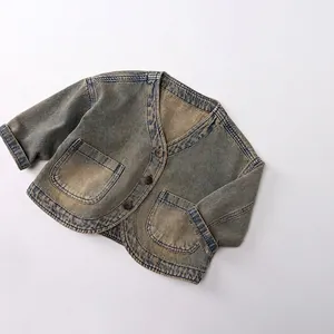 Detail shot of heavy washed denim jacket with V-neck and deep brown buttons for kids