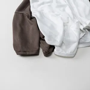 Close-up showing the soft knit fabric texture of children's white and brown summer shirts