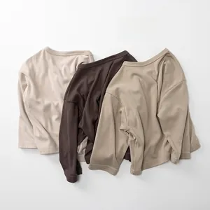 Close-up of soft cotton kids long sleeve tees in earthy tones with premium knit texture