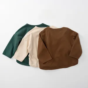 Détail de trois t-shirts à manches longues pour enfants en coton, coloris vert, beige et marron