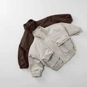 Close-up of kids utility jackets in brown and beige colors with large cargo pockets