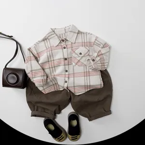 Flat lay of child cotton set with brown wide-leg pants and beige plaid shirt