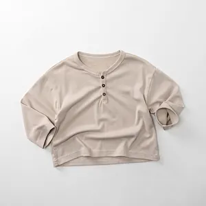 Detailed view of kids cotton long sleeve henley shirt with wood buttons and waffle texture
