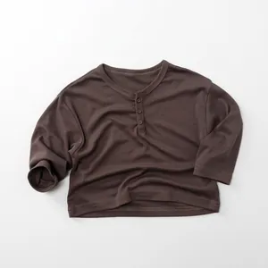 Detail view of children's dark coffee long-sleeve cotton shirt with a Henley neck and buttons