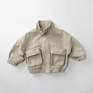 Detailed close-up of beige cotton cargo jacket for kids featuring large utility pockets