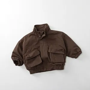 Detail view of dark brown kids utility jacket with stand collar and large cargo pockets