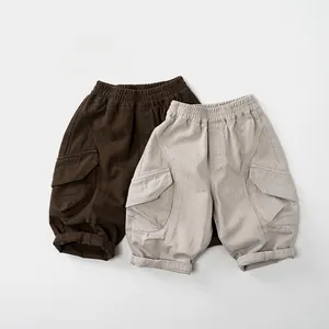 Detail of kids cotton cargo shorts in brown and beige featuring elastic waist and big pockets