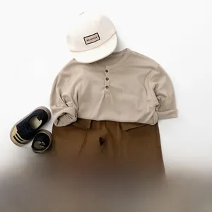 Flat lay of beige cotton long sleeve shirt, brown cargo pants and cap for toddlers
