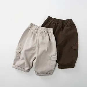 Detail view of cotton cargo shorts for children featuring elastic waist and utility pockets