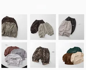 Flat lay of autumn knit cardigans and patterned trousers for children in earthy tones