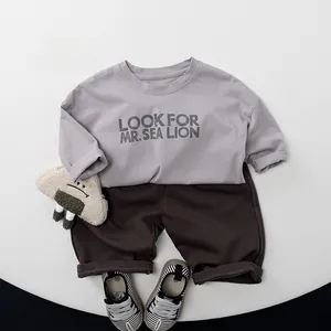 Flachbild von langärmeligem grauem Baumwoll-T-Shirt und dunkelbraunen Shorts für Kinder