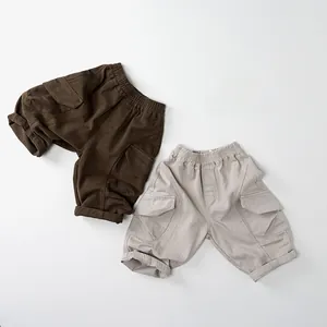 Detailed view of elastic waistband and cargo pockets on kids cotton utility trousers