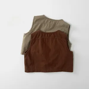 Flat lay of retro autumn kids canvas vests in brown and olive green colors