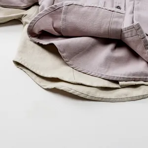 Détail de la couture d'ourlet et de la qualité des boutons sur chemises coton enfant