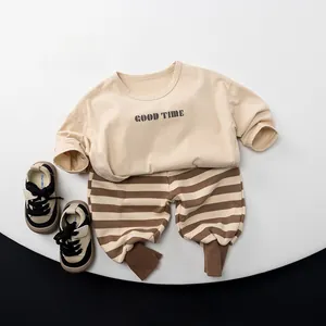 Détail d'un t-shirt à manches longues en coton avec imprimé et pantalon rayé