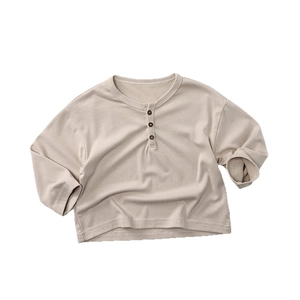 Kids soft cotton long sleeve Henley shirt in beige waffle knit fabric on white background