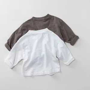 Detail der Slub-Baumwolltextur an braunen und weißen langärmeligen Kinder-T-Shirts