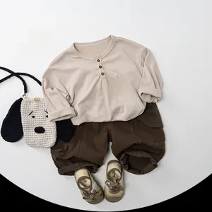 Close-up of children's cotton beige henley top and brown cargo pants outfit set