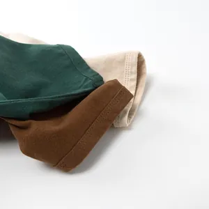 Gros plan détaillé sur les coutures renforcées des poignets de t-shirts en coton pour enfants