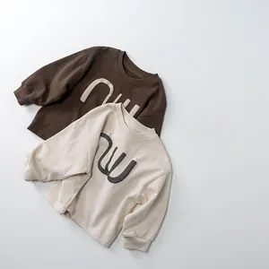 Détail de t-shirts en coton à manches longues pour enfants en marron et crème avec poignets