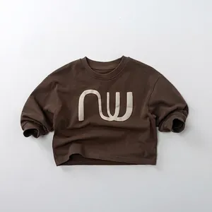 Détail d'un sweat à manches longues marron foncé avec imprimé nw blanc et col rond classique