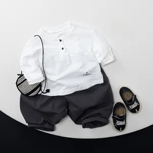 Flachbild-Set aus Kinder-Langarmshirt aus Baumwolle und dunkelgrauer weiter Stoffhose