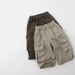 Détail de pantalon cargo enfant avec taille élastique et grandes poches à rabat en coton