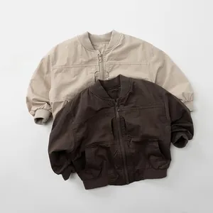 Flat lay of beige and brown kids workwear jackets with ribbed collars and utility pockets