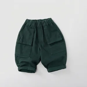 Détail du short cargo en coton vert foncé à coupe ample avec taille élastique et poches