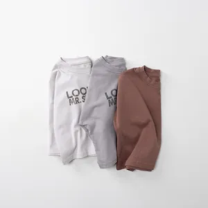 Flach liegende Detailansicht der Kinder-Baumwoll-Langarmshirts in neutralen Farbtönen