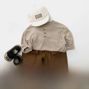 Vue à plat d'un pantalon cargo enfant marron foncé et d'un haut beige à manches longues