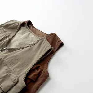 Detail view of retro khaki and brown kids vests with utility pockets and zippers