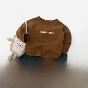 Vue à plat d'un sweat marron pour enfants avec pantalon en coton vert et baskets