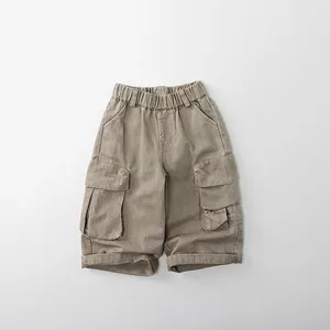Détail du pantalon cargo en coton kaki avec taille élastique et grandes poches à rabat