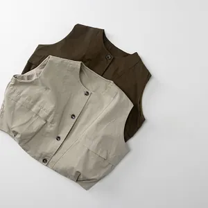 Vue détaillée du gilet enfant marron et beige avec poches et boutons de style vintage