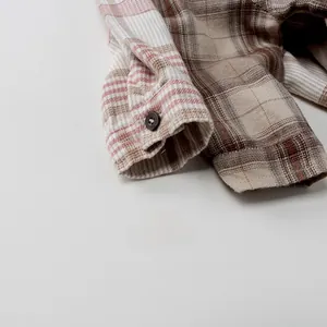 Vue détaillée du poignet d'une chemise à carreaux avec bouton en résine et coton épais