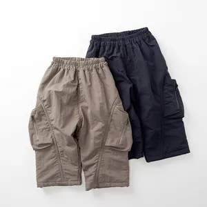 Detail of cargo pants elastic waistband and functional side pockets for kids