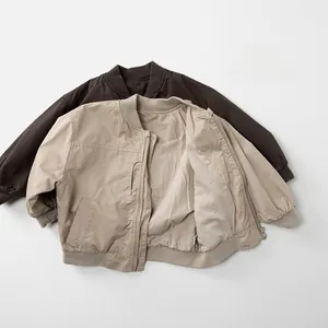 Close-up of kids' minimalist pilot jackets in dark brown and beige with ribbed cuffs