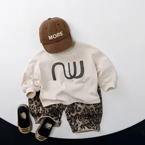 Tenue d'automne enfant avec sweatshirt beige 'nu', pantalon léopard et casquette