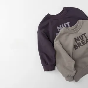 Close-up of ribbed cuffs and nut bread print on cotton kids sweatshirts in purple and taupe