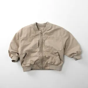 Detail of a beige kid's bomber jacket with ribbed collar and zipper closure style