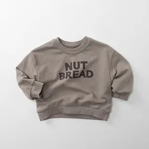 Detail of nut bread letter print and ribbed cuffs on kids brown cotton sweatshirt