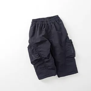 Detail view of dark grey cargo pants with elastic waist and zipper pockets for kids